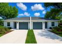 Paired single-story homes boast matching exteriors, manicured landscaping, and private driveways for each unit at 1251 Dosseywood Ln, Lakeland, FL 33811