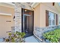 Stylish front entrance with stone accents, a decorative screen door, and manicured landscaping at 2612 Canyon Crest Dr, Lakeland, FL 33811