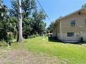 A spacious green lawn surrounds the home, creating a serene backdrop with mature trees and a neat landscape at 2073 Cr 428, Lake Panasoffkee, FL 33538