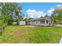 Expansive backyard view featuring a storage shed, lush green grass, and mature trees at 630 Pear St, Lakeland, FL 33815