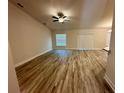 Bright living room featuring wood-look flooring, a ceiling fan, and a sliding glass door at 1259 Groveland Ln, Lakeland, FL 33811