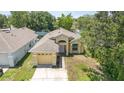 Aerial view of a well-maintained single-story home with an attached garage, driveway, and a neatly kept lawn at 1309 Timberbend Cir, Orlando, FL 32824