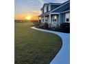 Beautiful home with a manicured lawn, landscaping, and a view of the sunset at 6726 Nw 54Th Loop, Ocala, FL 34482