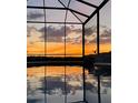An in-ground pool sits ready for a twilight swim with a stunning sunset view at 6726 Nw 54Th Loop, Ocala, FL 34482