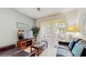 Inviting living room with neutral walls, tile flooring, a glass coffee table, and access to the outdoor patio at 7654 Comrow St # 202, Kissimmee, FL 34747