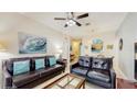 Comfortable living room with large leather sofas, ceiling fan, decor, and seamless flow into the dining area at 7654 Comrow St # 202, Kissimmee, FL 34747