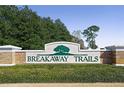 Breakaway Trails community entrance sign with manicured hedges and brick accents, signaling a welcoming neighborhood at 24 Lake Vista Way, Ormond Beach, FL 32174