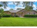 Brick home with well-maintained lawn and landscaping, showcasing a classic and inviting exterior at 24 Lake Vista Way, Ormond Beach, FL 32174