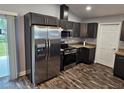 A modern kitchen featuring stainless steel appliances, granite countertops, and stylish dark cabinetry at 1121 W 9Th St, Lakeland, FL 33805