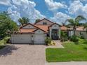 Charming home featuring a three-car garage, lush landscaping, and a brick paved driveway at 3939 Sunset Lake Dr, Lakeland, FL 33810