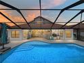 A luxurious pool area featuring a screened-in lanai, a built-in outdoor kitchen, and a refreshing pool at 3939 Sunset Lake Dr, Lakeland, FL 33810