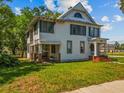 Exterior view of a white two-story house with green shutters, a front porch, and a well-maintained lawn at 485 E Stanford St, Bartow, FL 33830