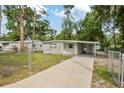 Cozy one-story home with a covered carport, front lawn, and chain link fence for added security at 728 Trenton Rd, Lakeland, FL 33815