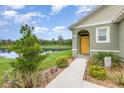 Inviting home exterior with a yellow door, lush landscaping, and a serene lake backdrop at 3333 Costello Cir, Winter Haven, FL 33884