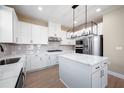 Bright kitchen with white cabinets, stainless appliances, stylish light fixture, and center island at 7890 Somersworth Dr, Kissimmee, FL 34747