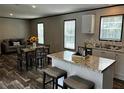 Open-concept kitchen with stainless steel appliances, granite countertops, and a central island with seating at 9494 Se 144Th Pl, Summerfield, FL 34491