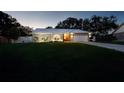 Inviting single-story home with lush green lawn, white fence, and stone-accented facade at twilight at 3610 Amber Ln, Lakeland, FL 33812