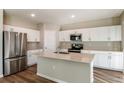 Bright kitchen featuring stainless steel appliances, an island, and white cabinetry at 4035 Gardenia Ave, Lake Hamilton, FL 33851