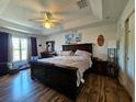 Inviting bedroom features a tray ceiling, a large window, and wood-look flooring at 205 Golf Aire Blvd, Haines City, FL 33844