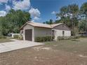 Spacious home featuring an attached garage, a well-manicured lawn, and mature trees at 2271 Crystal Grove Ln, Lakeland, FL 33801
