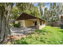 Exterior home view with charming carport, mature trees, and well-maintained lawn at 519 Market W Sq, Lakeland, FL 33813