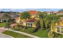 Attractive home featuring a tile roof, a paver driveway, and mature palm trees at 1140 Terralago Way, Kissimmee, FL 34746