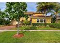 Charming home with a well-maintained lawn, mature trees, and a brick paver driveway at 1140 Terralago Way, Kissimmee, FL 34746