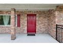 Inviting front porch featuring a striking red door and brick facade at 1212 Blake Ave, Auburndale, FL 33823