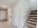 Entryway with carpet, stairs, and a view into an adjoining living area with natural light at 1424 Axel Cir, Winter Haven, FL 33880