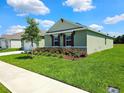 Beautiful exterior showing a green home with a well-kept lawn and garden in the front at 3148 Caspian Feather St, Bartow, FL 33830