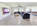 Spacious living room featuring an oversized sectional sofa, large windows, and contemporary decor at 3148 Caspian Feather St, Bartow, FL 33830