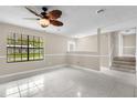 Bright living room featuring tile floors, a large window, and a ceiling fan with decorative leaf-shaped blades at 3331 Lime Tree Dr, Edgewater, FL 32141