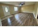 Open-concept living area featuring stylish laminate flooring, neutral walls, a fan, and natural light at 45652 Ohio St, Paisley, FL 32767