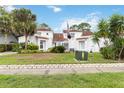 Home featuring lush landscaping, a red tile roof, white stucco, and an American flag at 2524 Albion Ave, Orlando, FL 32833