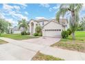 Beautiful exterior elevation with palm trees, manicured lawn, and brick-paved driveway at 239 Beacon Pointe Dr, Ocoee, FL 34761