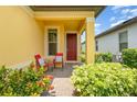 Inviting front porch with chairs, complemented by colorful flowers and lush greenery at 472 Pontevedra Rd, Davenport, FL 33837
