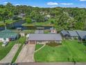 Aerial view of a home with a metal roof, a spacious backyard, and access to a tranquil waterway at 718 Cr 467, Lake Panasoffkee, FL 33538