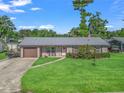 Charming single-story home with a lush green lawn, driveway, and inviting front porch at 718 Cr 467, Lake Panasoffkee, FL 33538