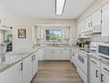 Bright kitchen featuring white cabinets, modern appliances, and views of the backyard at 718 Cr 467, Lake Panasoffkee, FL 33538