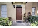 Inviting front door with a keypad, lush plants, and exterior lighting creating a warm entry to the home at 6300 Raleigh St # 102, Orlando, FL 32835
