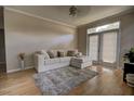 Cozy living room with hardwood floors, a comfortable sofa, and large windows filling the space with natural light at 6300 Raleigh St # 102, Orlando, FL 32835