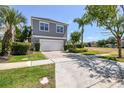 Two-story home with a two-car garage, neatly landscaped yard, and paved driveway at 7523 Excitement Dr, Kissimmee, FL 34747