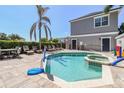 Private backyard pool and spa area with lounge seating and a basketball hoop at 7523 Excitement Dr, Kissimmee, FL 34747
