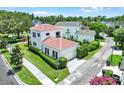 Aerial view of a home with a red tile roof, two-car garage, and a lush backyard at 740 Oak Shadows Rd, Kissimmee, FL 34747