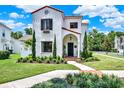 Elegant two-story stucco home with a red tile roof and manicured landscaping at 740 Oak Shadows Rd, Kissimmee, FL 34747