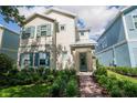Charming two-story home with teal shutters, landscaped yard, and a welcoming brick pathway to the front door at 1430 Reunion Blvd, Reunion, FL 34747