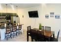 Open-concept kitchen and dining area with modern stainless steel appliances and seating for six at 3428 Tranquil Trail, Kissimmee, FL 34747