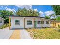 Charming single-story home featuring a well-maintained lawn, a vibrant teal door, and a covered front porch with wood pillars at 4116 Winona Dr, Orlando, FL 32812