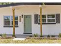 Charming exterior featuring a welcoming sage green front door, brick accents, and a well-manicured lawn with brick borders at 4116 Winona Dr, Orlando, FL 32812