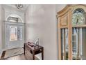 Welcoming foyer featuring a wooden table, grandfather clock, and decorative glass entry door at 7890 Lake James Blvd, Lakeland, FL 33810